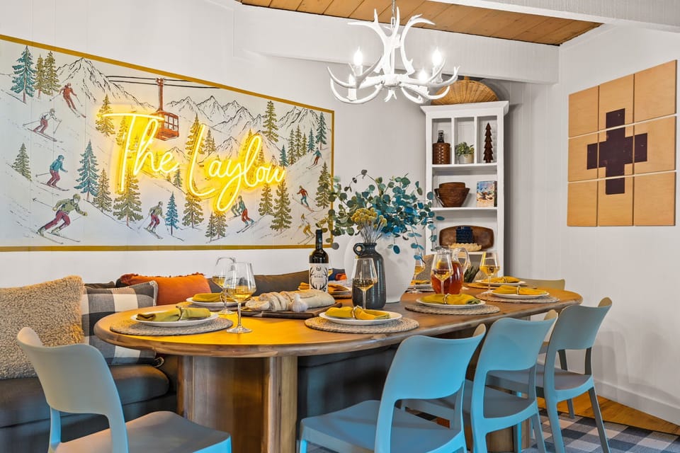 Cozy mountain-inspired dining room with neon art and seating for 8