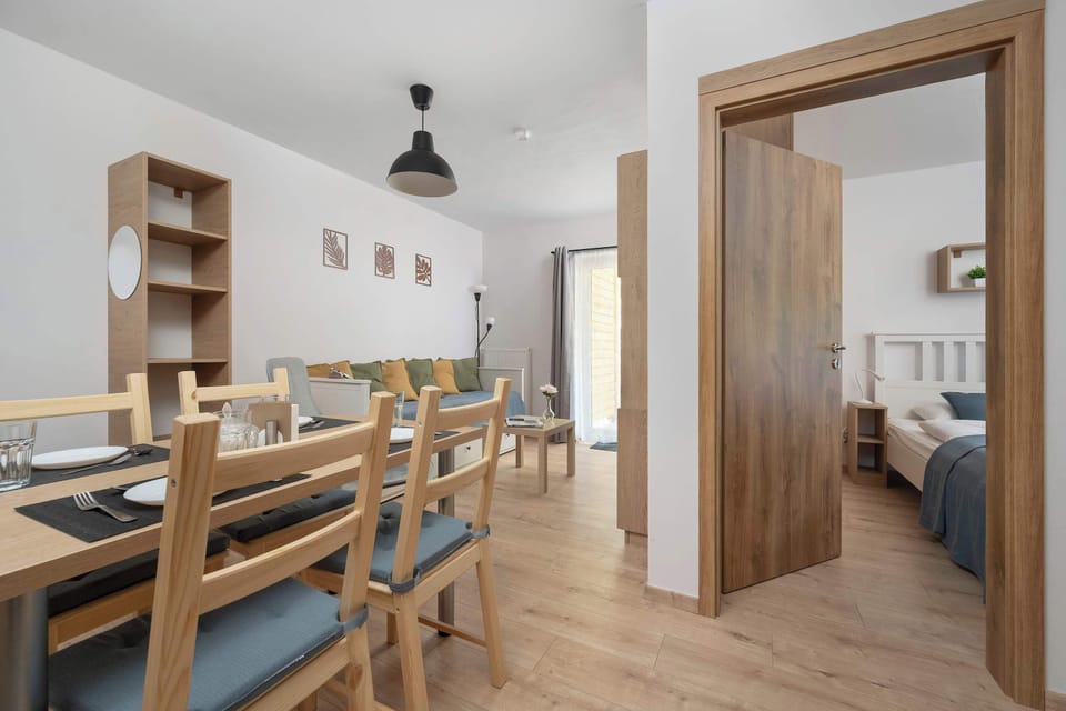 The interior hallway connects the dining area to other rooms through solid wooden doors. The space feels open, airy, and cohesively designed with matching wooden accents.