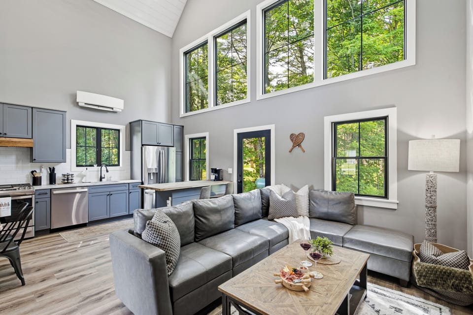 Rest comfortably in a spacious bedroom with large windows and a calm, inviting atmosphere.