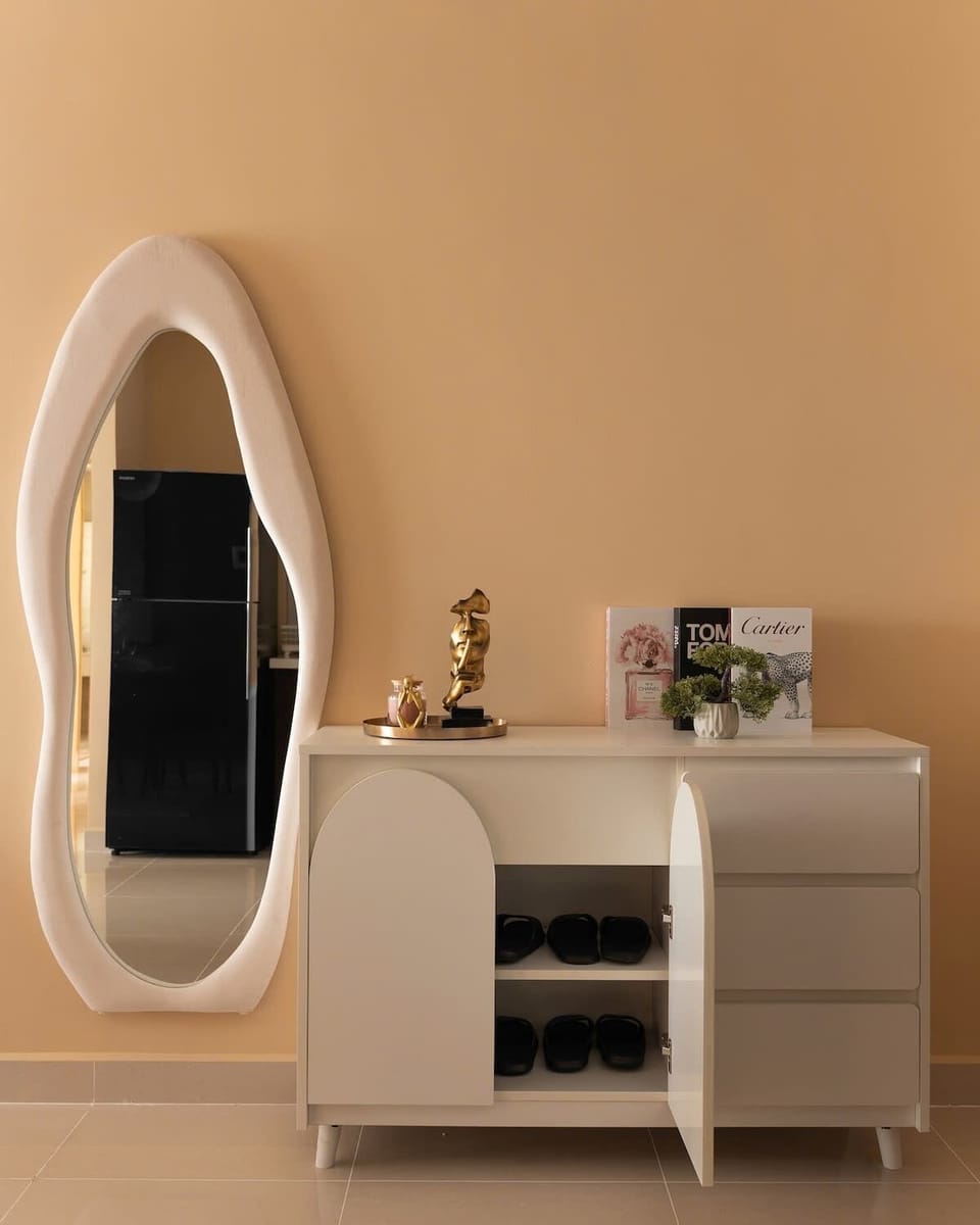 Stylish entryway with sculptural mirror, modern shoe cabinet, and decor. Slippers are provided for every guest. The mirror reflects the kitchen opposite and is perfect for outfit checks or selfies as you come and go.