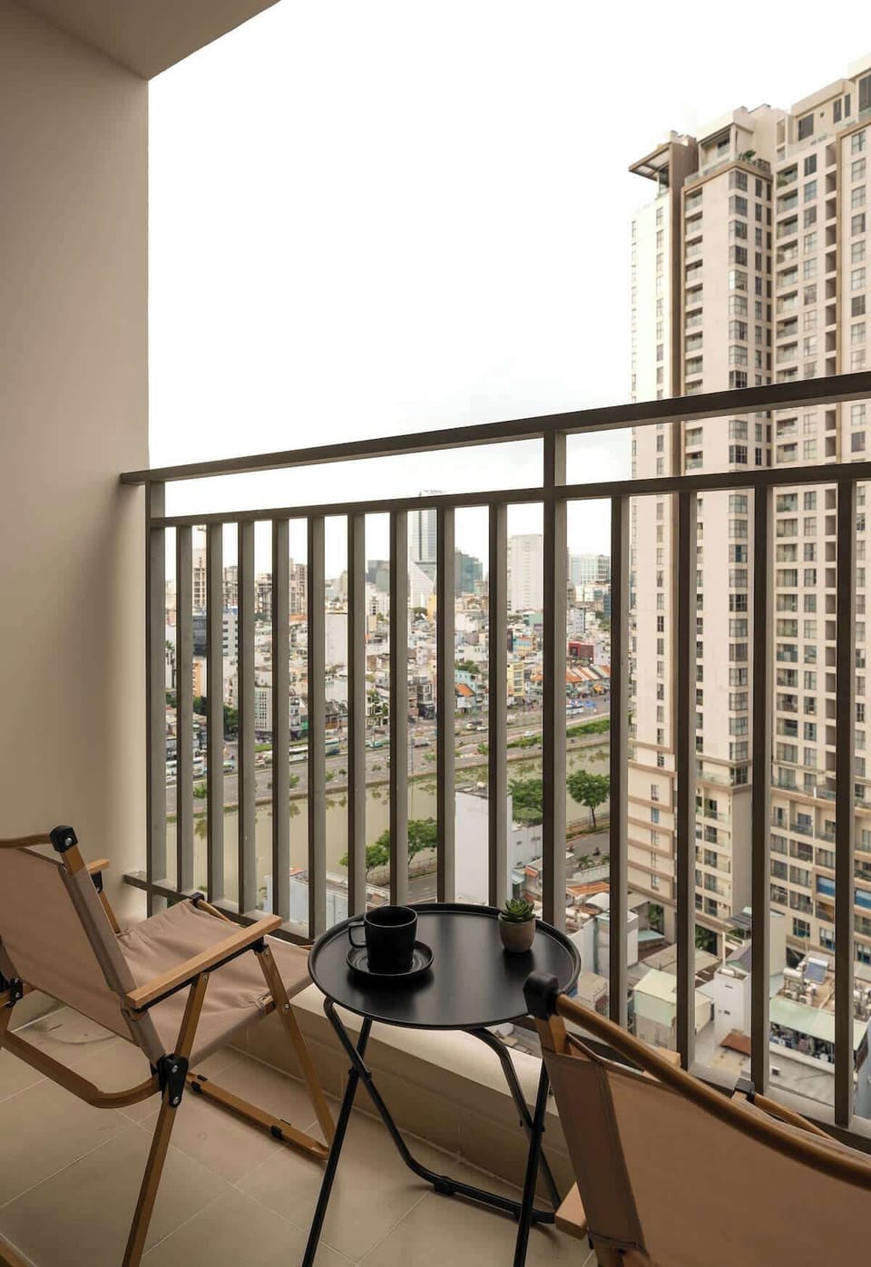 Main balcony view featuring two comfortable seats and an outdoor table perfect for relaxing with a cup of coffee or tea.