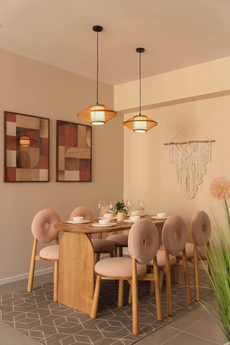 Large dining area with 6 comfortable velvet seats and two hanging suspended lights.