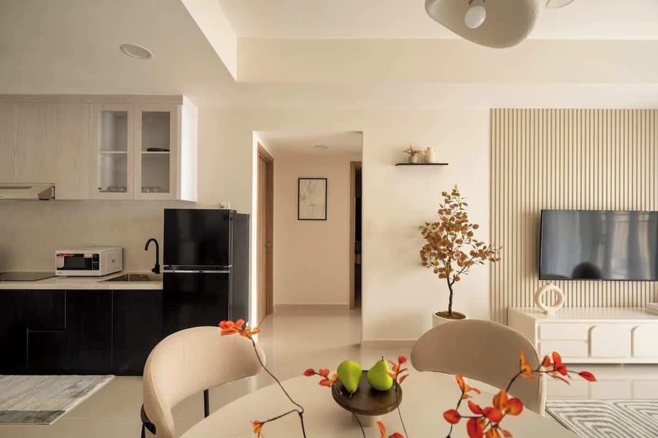 Open plan layout with kitchen and dining in view. Small hallway leads to three rooms. Left is the queen bedroom with no window. Straight ahead is the bathroom. Opposite the queen room is the double bedroom. Smart TV and feature wall in lounge.