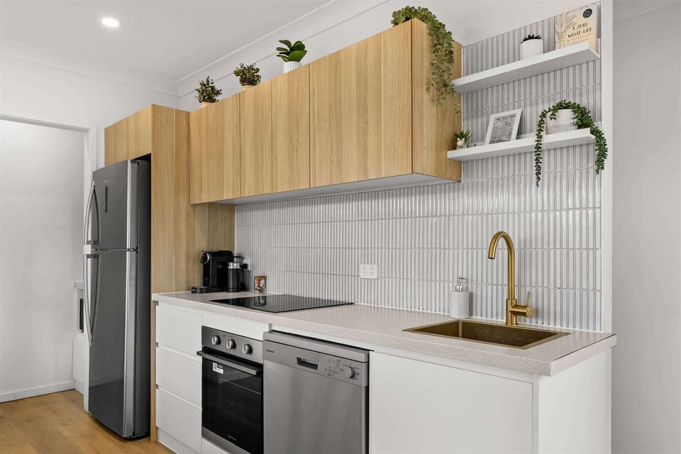 "Spacious kitchen with a full-size fridge, oven, and dishwasher, opening onto a dining area — perfect for cooking up a meal and unwinding together."

Option 4 (guest-focused):
"Kitchen comes fully stocked with a large fridge, oven, and dishwasher, pl