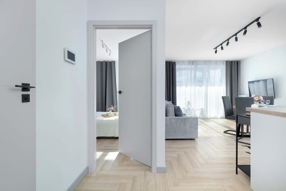 A bright hallway with light wooden flooring connects the different rooms of the apartment.