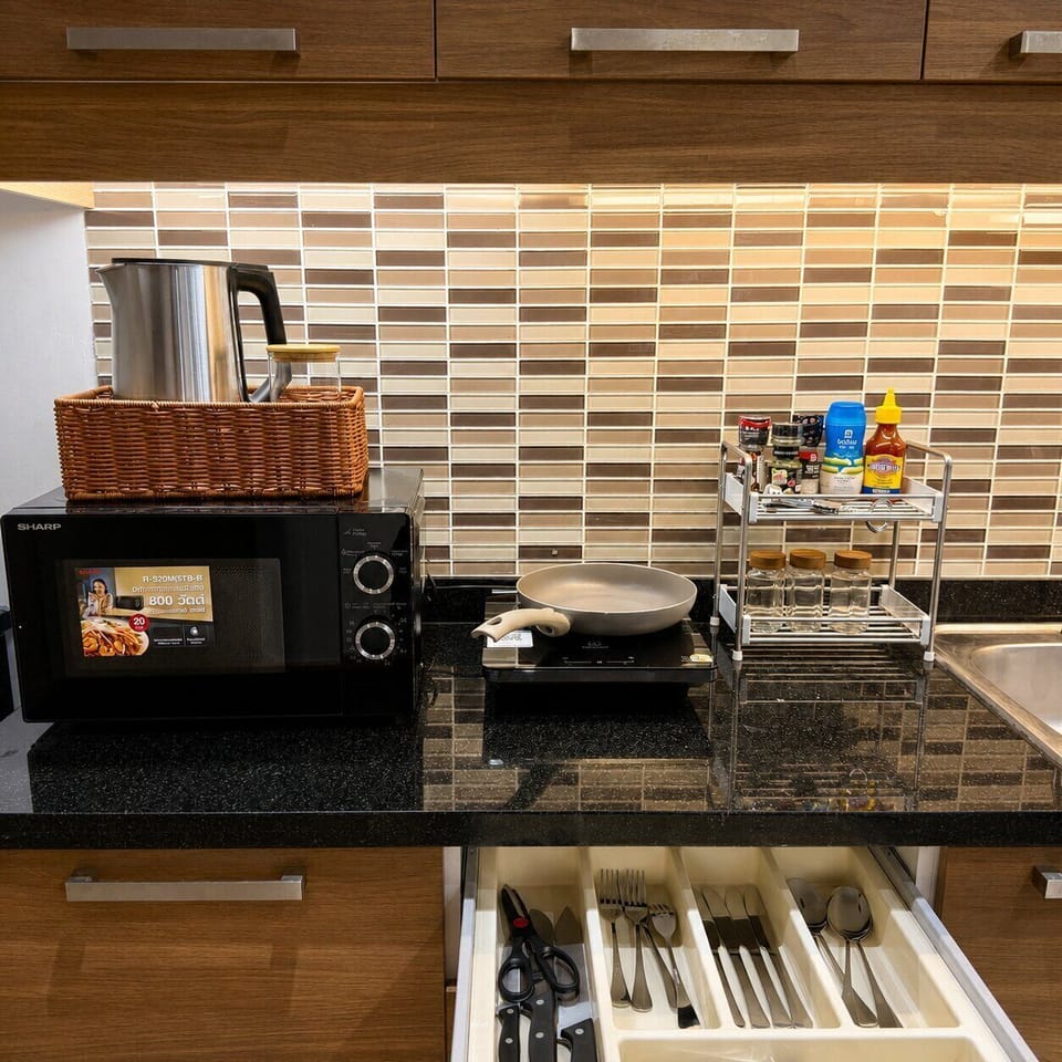 Well-stocked kitchenette with cooktop, microwave, and organized essentials