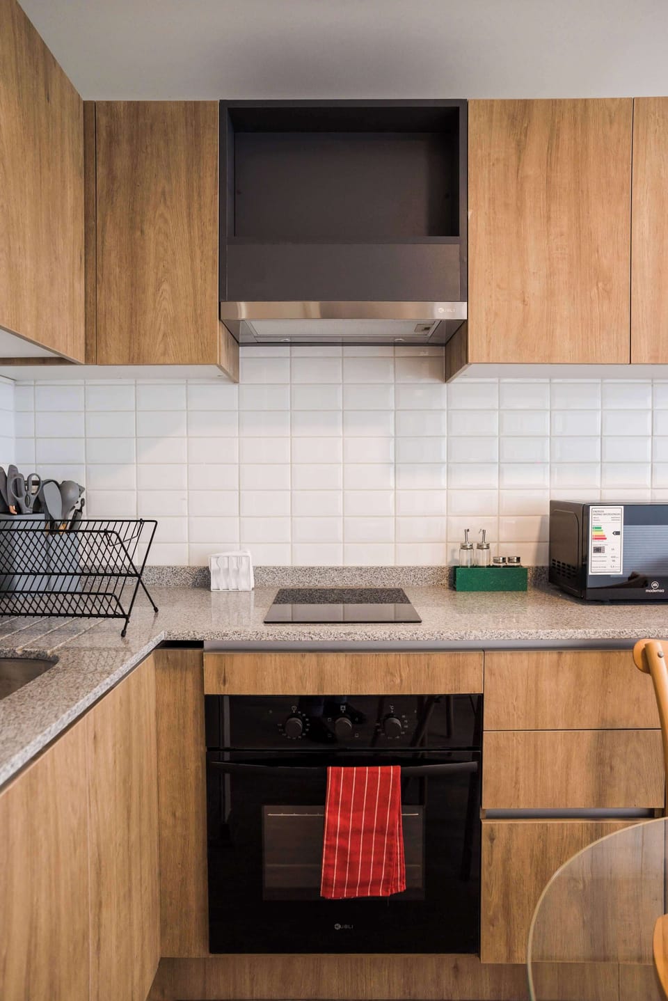 Sleek and modern kitchen with all essentials for your culinary needs in a cozy studio apartment.