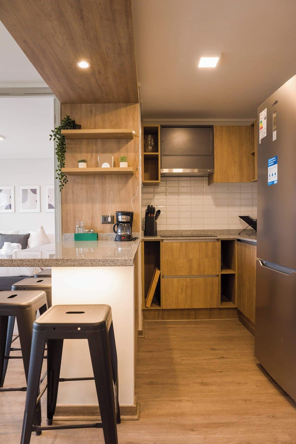 Modern kitchen with sleek wooden finishes and cozy seating, perfect for enjoying a morning coffee.