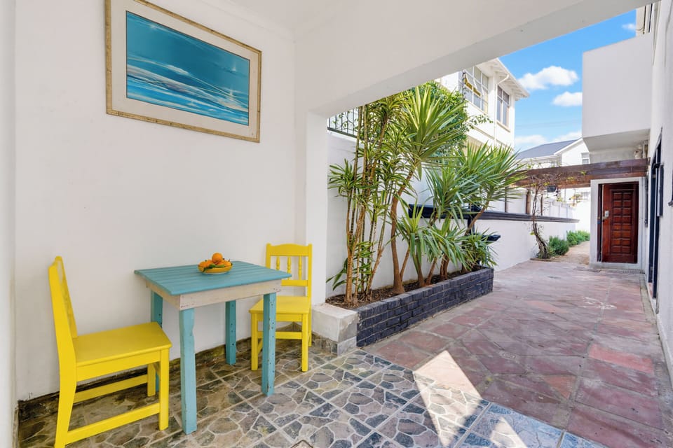 Bright tropical entry patio with cozy seating and sunny outdoor charm