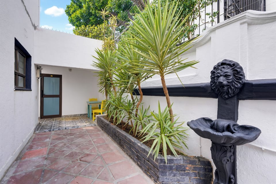 Charming courtyard with tropical plants, fountain, and cozy seating nook