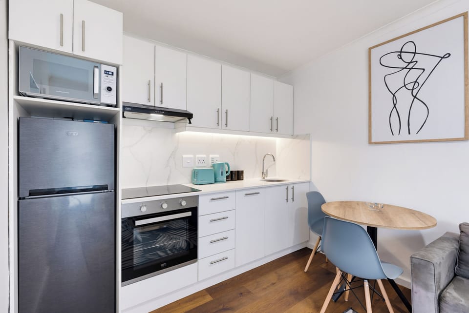 Bright modern kitchenette with dining nook and full cooking essentials