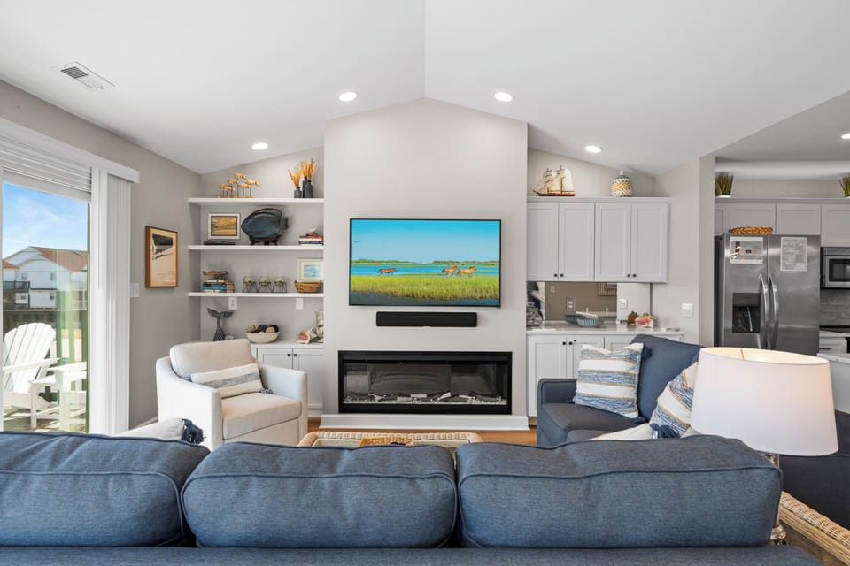 Sink into plush seating by your cozy fireplace, where the flat-screen TV awaits your favorite shows after beach days.