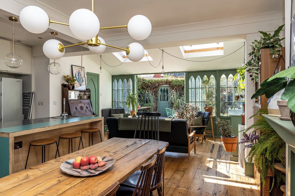 Sun-filled dining and lounge space with skylights and garden views