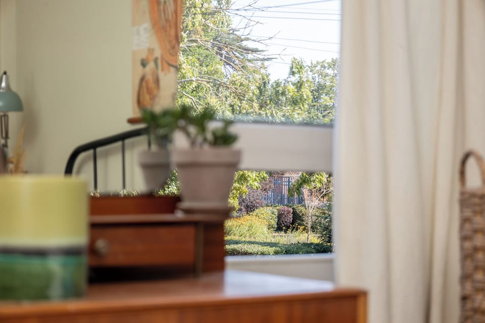 Cozy bedroom nook with sunny garden views and warm, inviting decor