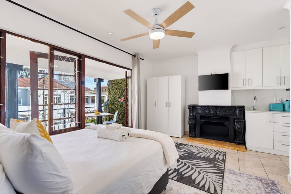 Bright studio with balcony, kitchenette, and charming decorative fireplace
