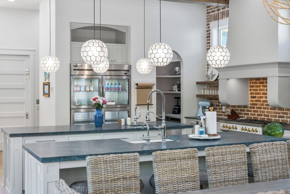 A bright, beautifully designed kitchen features two large island where you can gather, cook, and share memorable meals together in comfort and style.