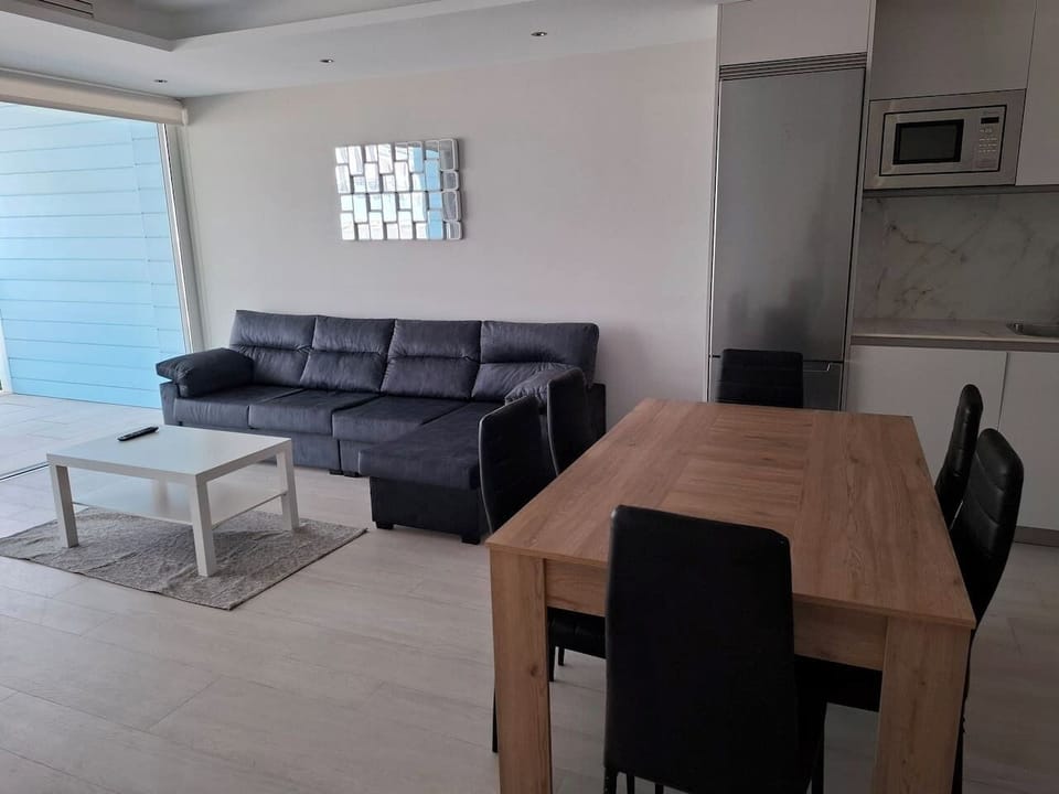 Bright, open-plan living and dining area designed for comfort. Relax on the sofa or enjoy meals at the oak dining table, all just steps away from your private, sun-drenched balcony at Marina Club.