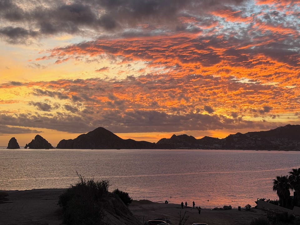 Marvel at the vibrant sky painting Land's End in fiery hues.