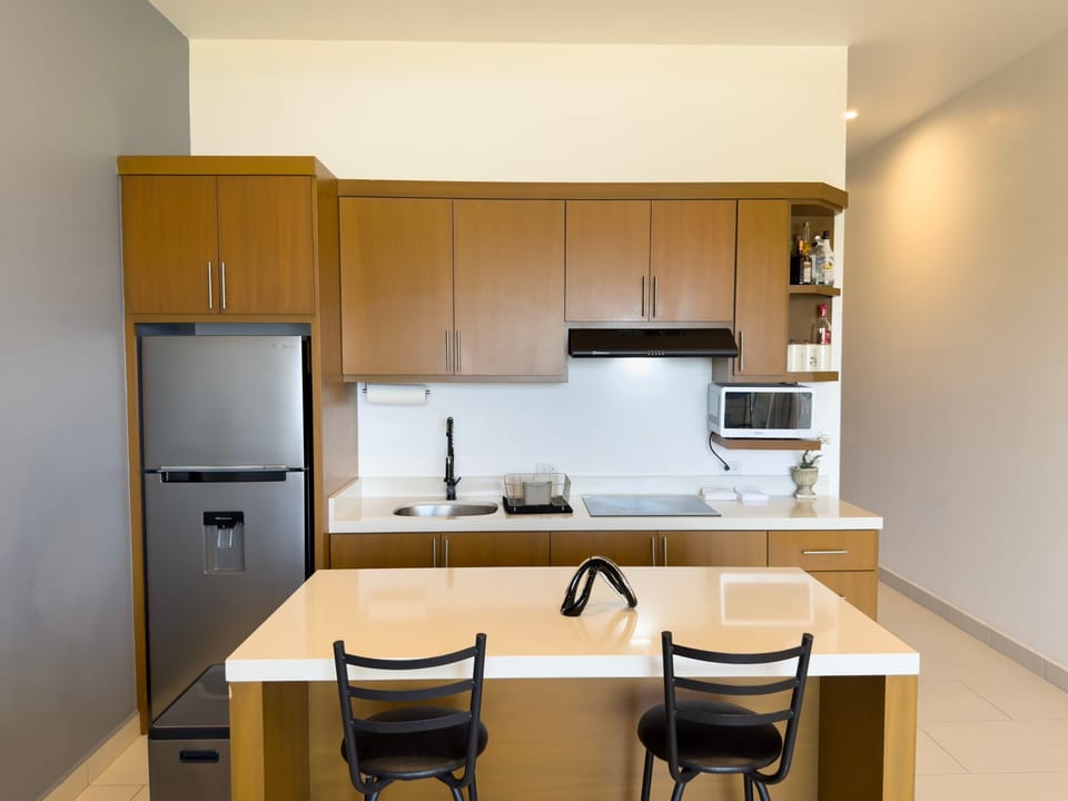 Sleek wooden cabinetry and a large island make cooking a joy.