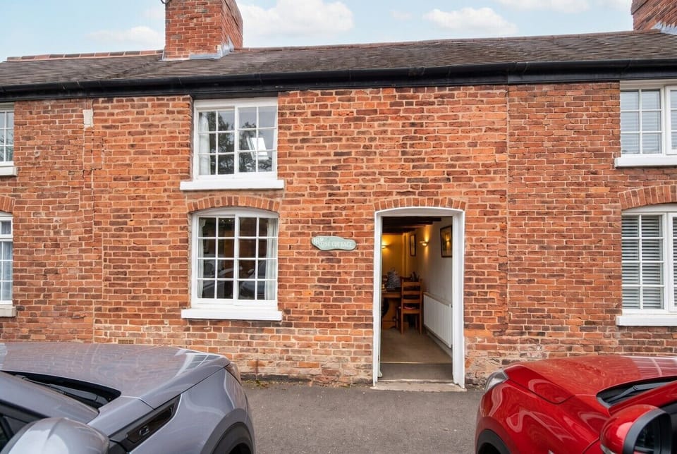 Classic brick cottage frontage on a quiet village lane with parking
