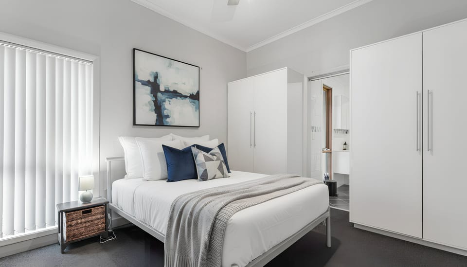The primary bedroom includes a comfortable double bed, wall-mounted TV and soft bedding, providing a restful space to ease into the evening.