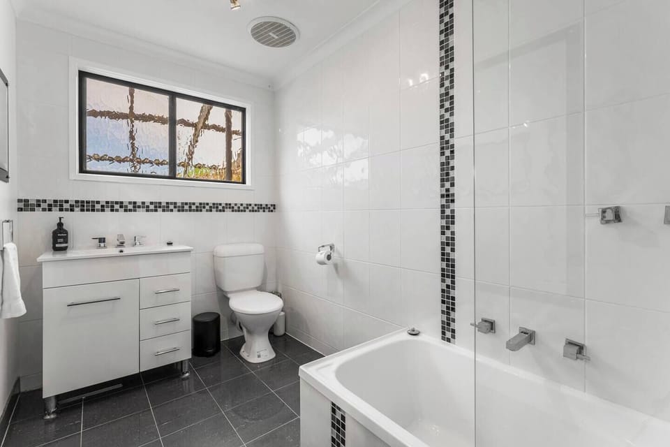 The main bathroom features a soothing bathtub ideal for long soaks after exploring Ballarat.