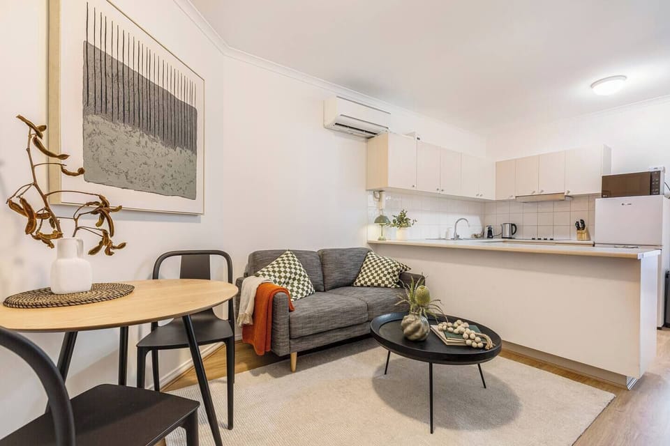 Unwind on the comfortable sofa in the living area, where split-system air conditioning and a TV create an easy spot to relax after exploring nearby shops and bars.