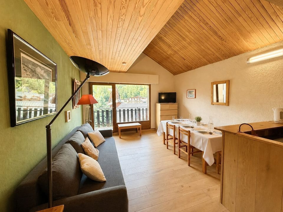 Gather around the dining table, framed by warm wood tones and a mountain view through the window.