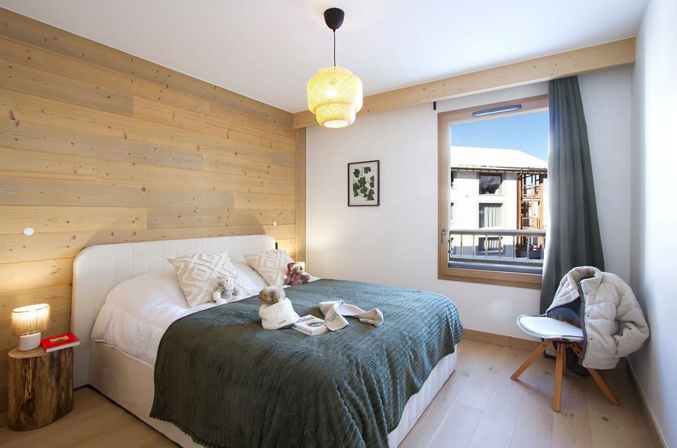 Wood-panelled walls frame the double bed, ready for a rest after a day on the pistes.