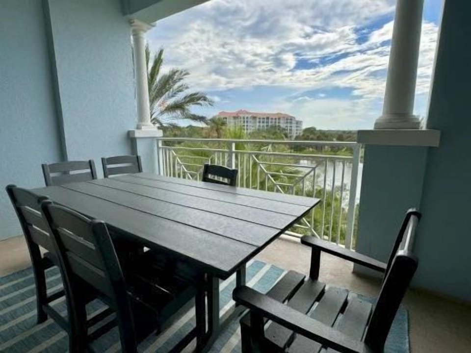 Private balcony with a large table for outdoor dining overlooking the waterway and green surrounds