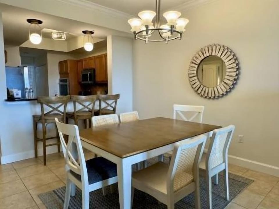 Dining table beneath statement pendant lights — open to the kitchen and living area