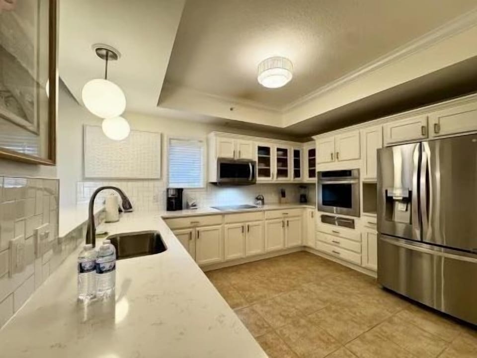 Bright kitchen with white cabinetry, full-sized stainless appliances, and a clean open layout