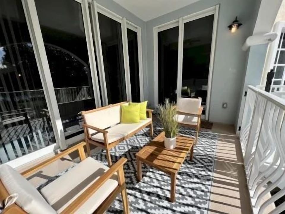 Private balcony with wooden chairs, a small table, and a patterned rug