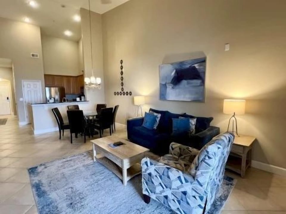 Living area with soft blue accents, plush seating, and natural light through large windows