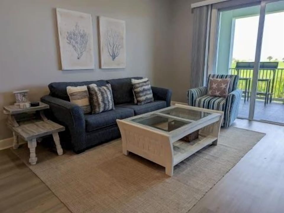 Living area with plush seating, flat-screen TV, and nautical accents throughout
