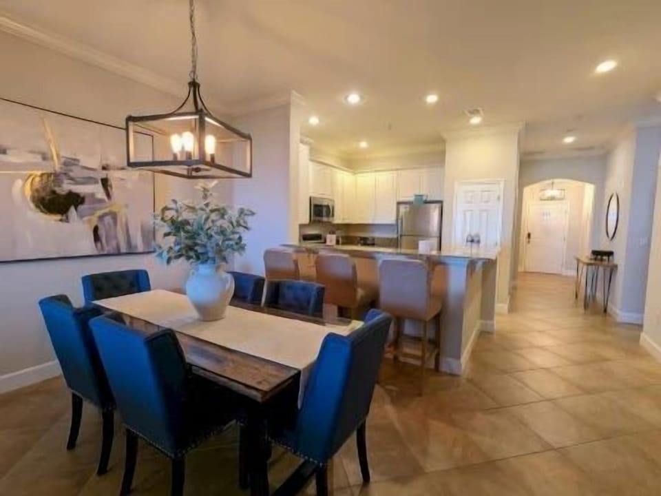 Dining table for six with soft overhead lighting — open to the kitchen and living area