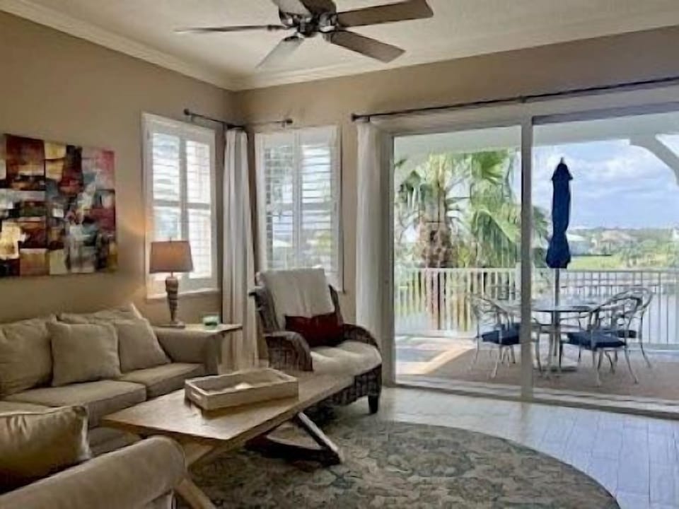 Sunlit living room with a sliding door to the private balcony and lake views beyond