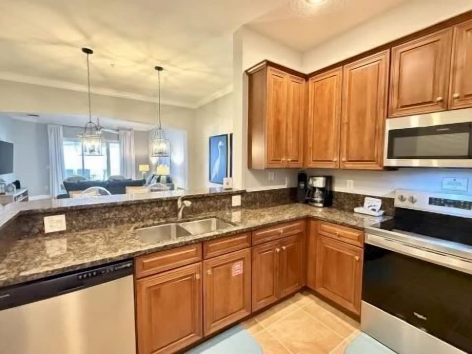 Kitchen with rich wood cabinetry, granite counters, and full-sized stainless appliances