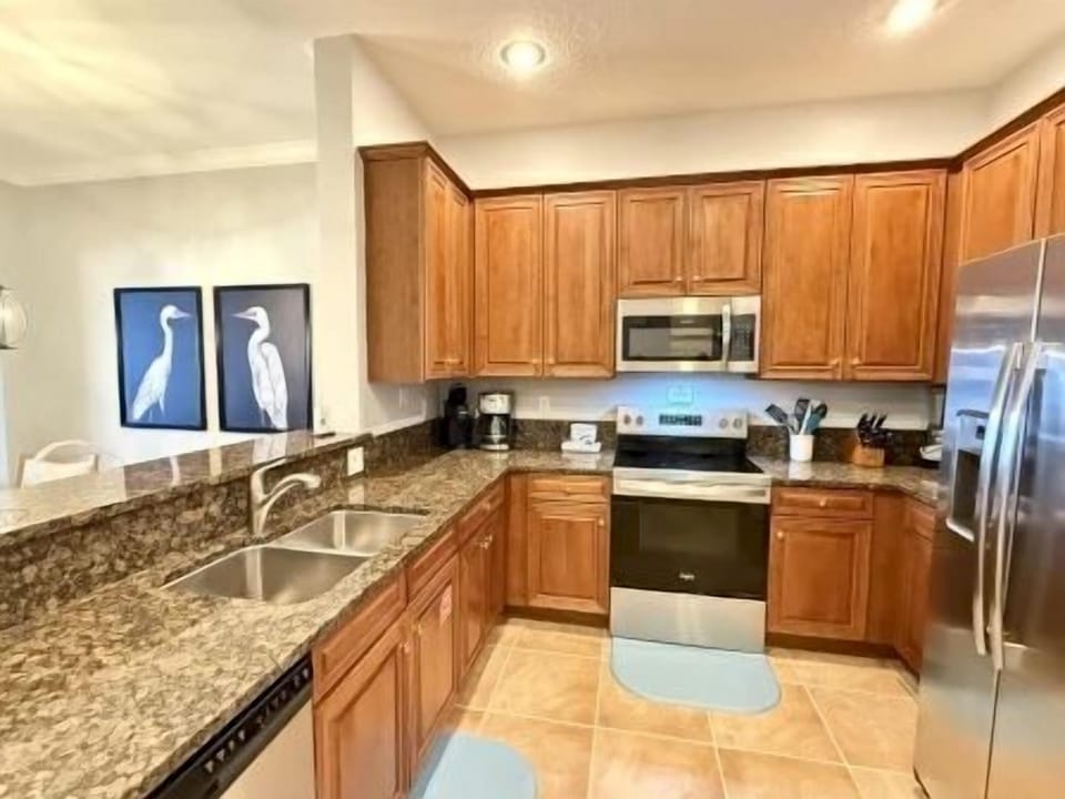 Second kitchen angle showing the two-seat bar counter and stainless appliances