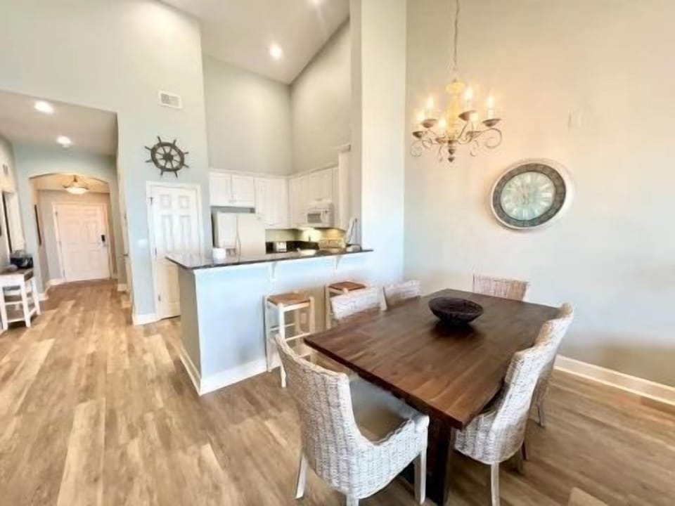Rustic dining table with wicker chairs for six — open to the kitchen for easy family meals