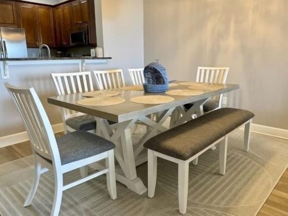 Dining table with eight seats beneath soft overhead lighting — room for the whole group to sit down