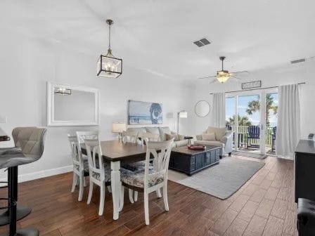 Dining table for six beside the balcony doors, with palm trees and ocean views beyond