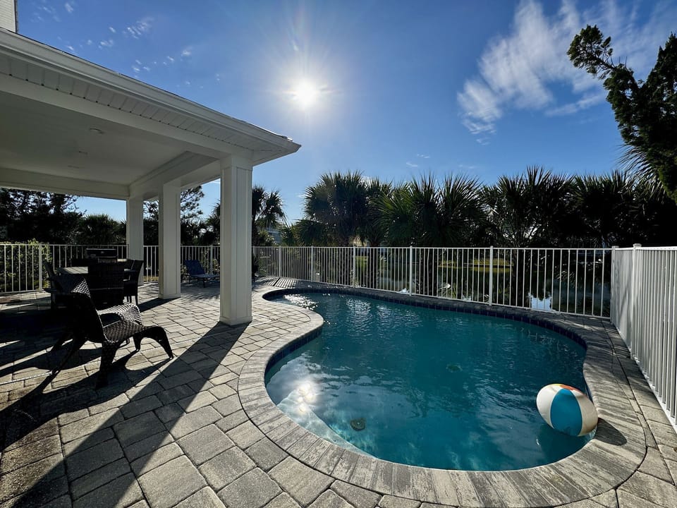 The private pool faces the waterfront — covered lanai with gas grill sits right alongside