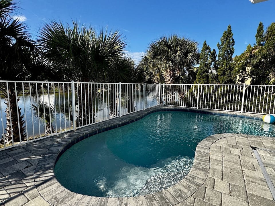 Your waterfront-facing private pool with swaying palms — the covered lanai and gas grill are just steps away