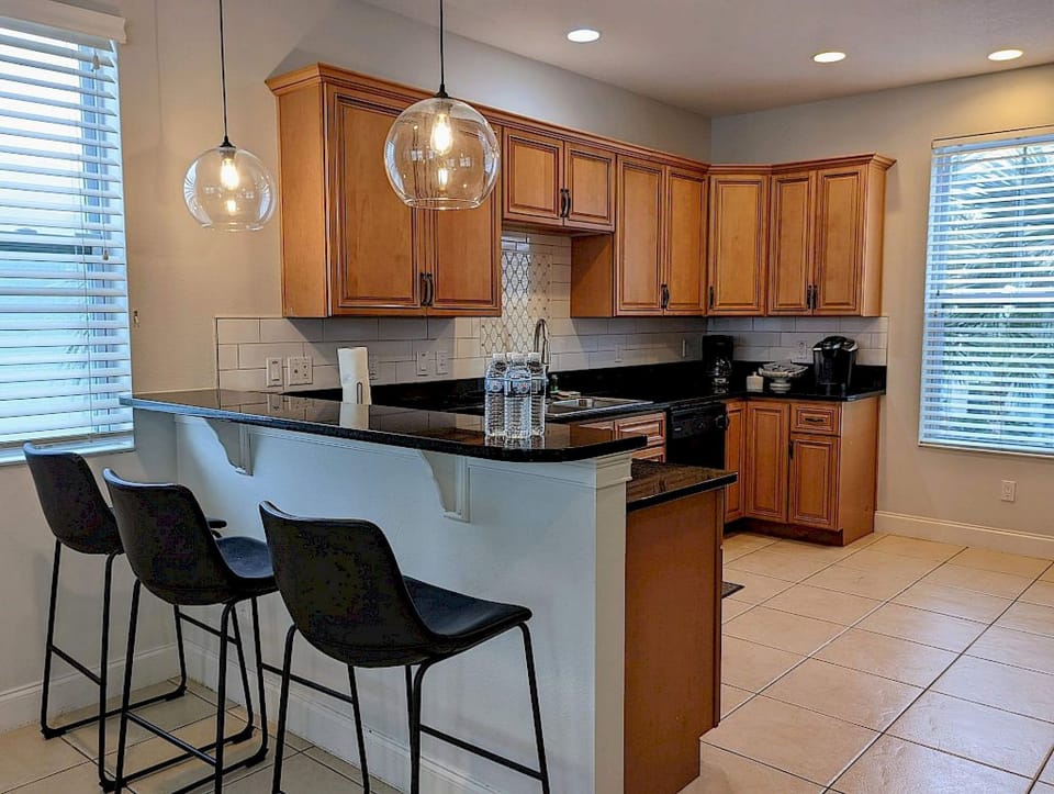 Kitchen area with open shelving, bar counter, and light wood accents