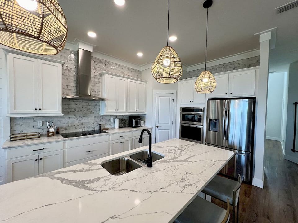 Kitchen with white cabinetry, open layout, and natural light — easy for group meal prep