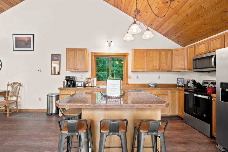 The full kitchen has bar seating for four at the counter and opens to the rest of the main level under the vaulted ceiling.
