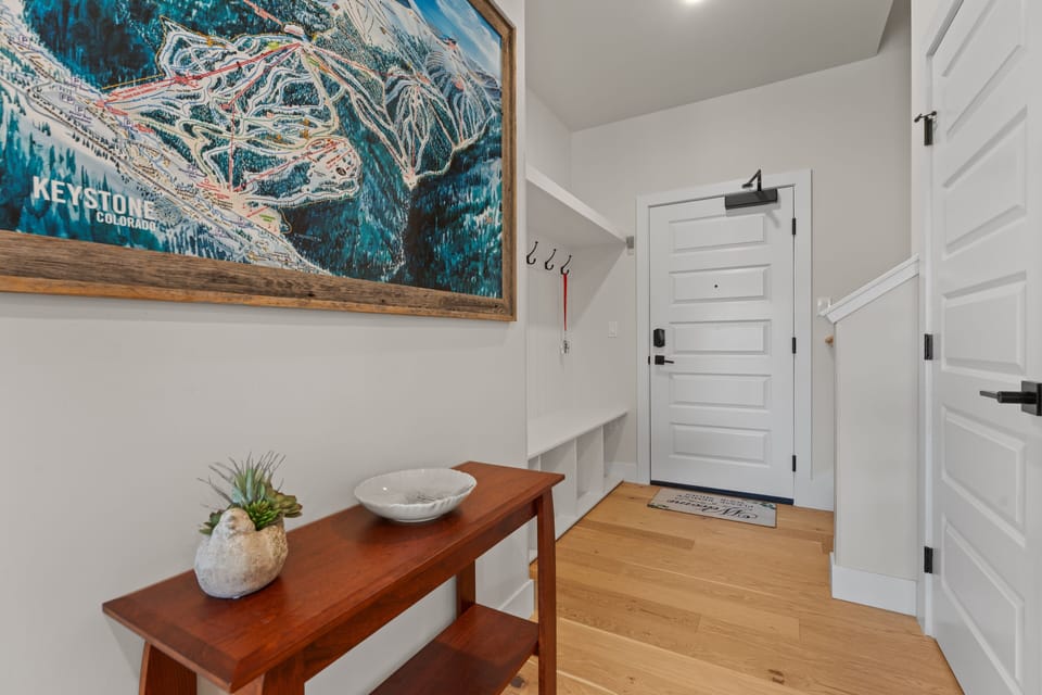 A bright entryway welcomes you with warm wood floors, high vaulted ceilings, and mountain-inspired decor that sets the tone for your alpine getaway.