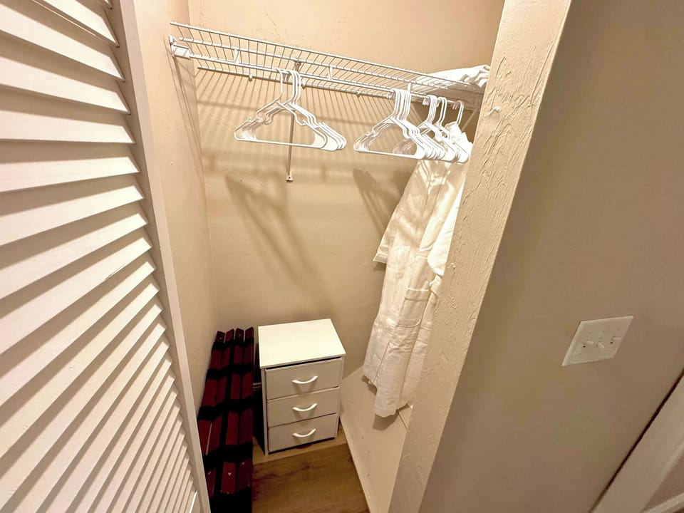 Closet with provided storage space, shelving, hangers, luggage racks, and hotel-quality robes. 