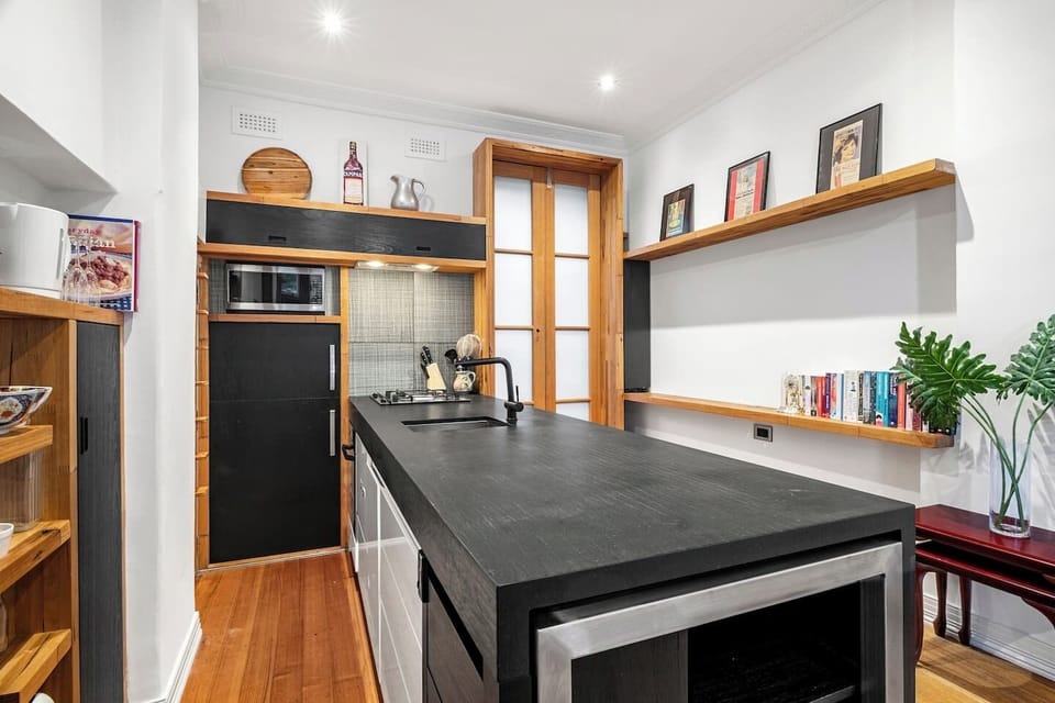 Prepare meals in the fully equipped kitchen, featuring a gas cooktop, oven, microwave, toaster, kettle, fridge, and cooking essentials.